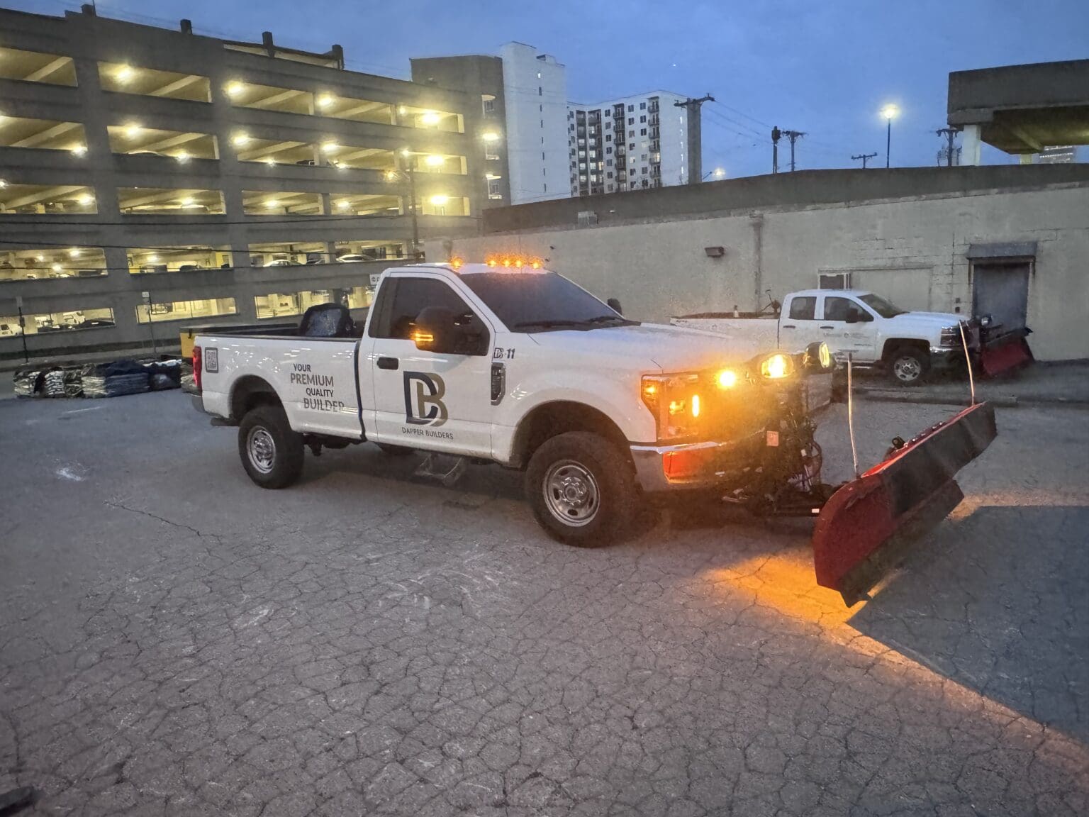 Dapper Builders plow truck clearing a commercial parking area